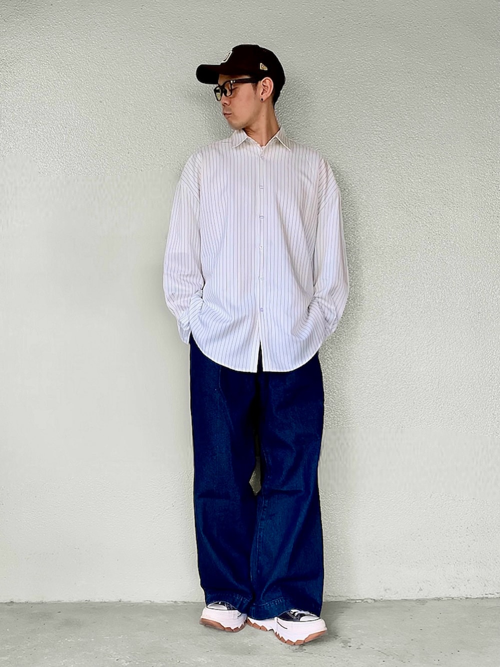 ホワイト系のシャツ/ブラウス、ブルー系のデニムパンツ、ブラック系のスニーカーを着用したメンズの秋コーディネートの1枚目の写真