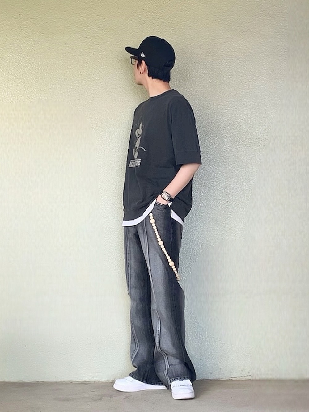 ホワイト系のスニーカー、ブラック系のTシャツ/カットソー、ブラック系のデニムパンツを着用したメンズの夏コーディネートの1枚目の写真