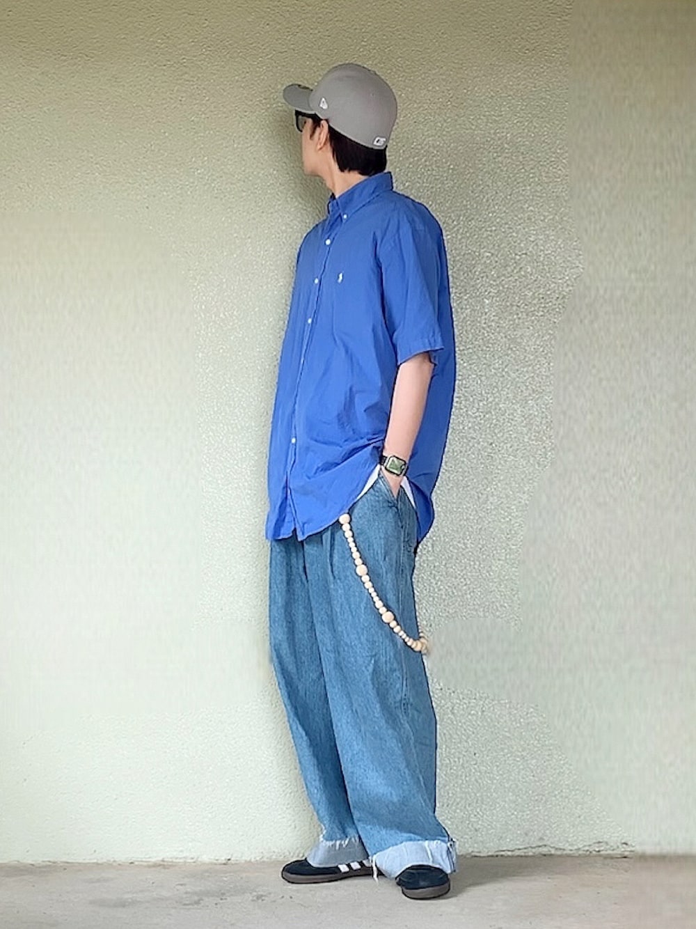 ブラック系のスニーカー、ブルー系のシャツ/ブラウス、グレー系のキャップを着用したメンズの夏コーディネートの1枚目の写真