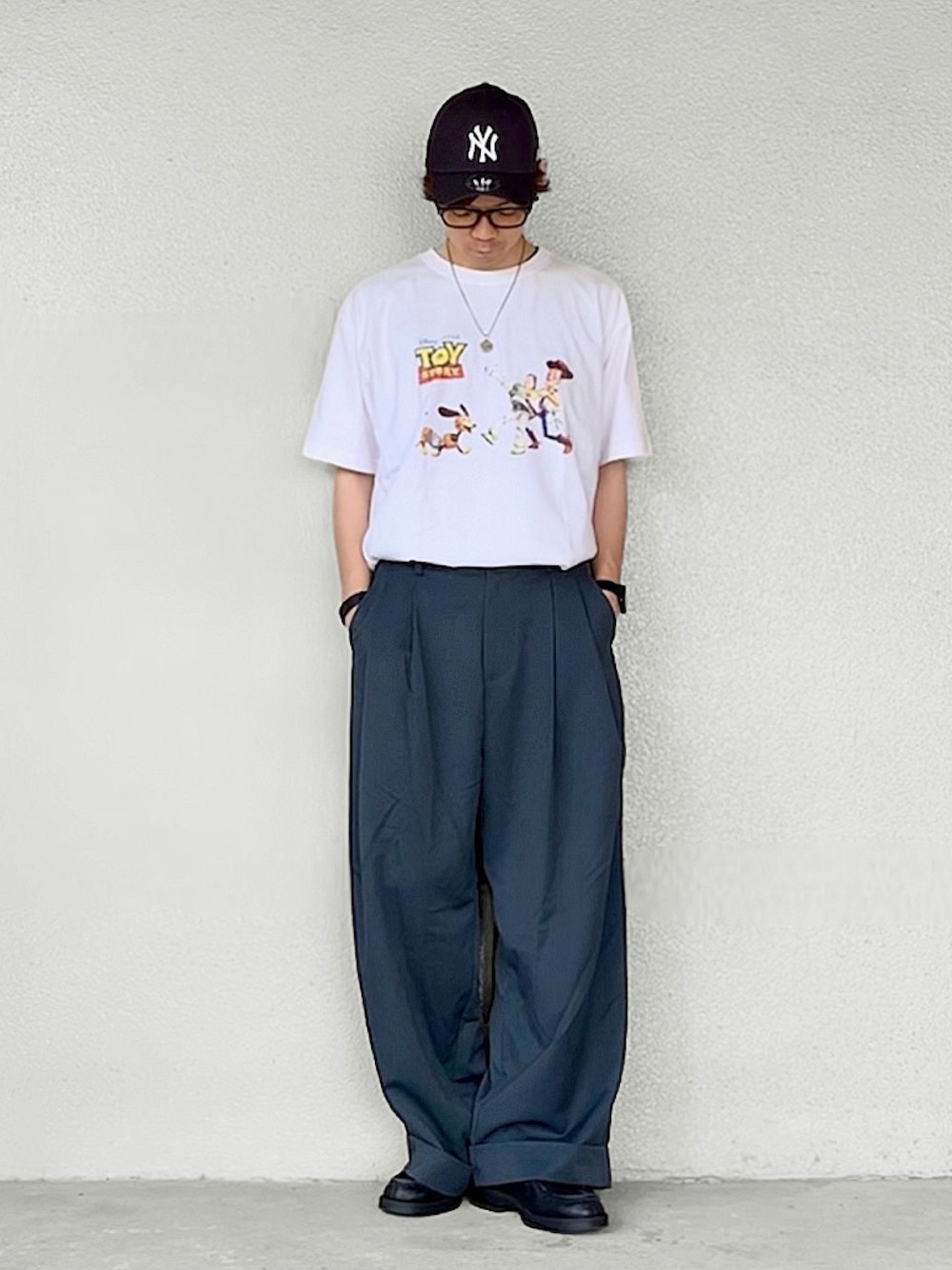 ホワイト系のTシャツ/カットソー、ブルー系のスラックス、ブラック系のドレスシューズを着用したメンズの秋コーディネートの1枚目の写真