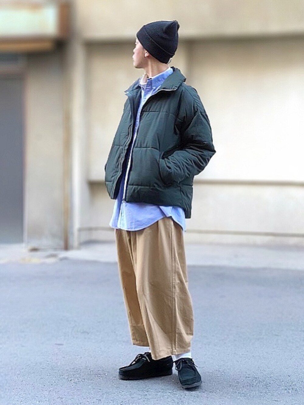 グリーン系のダウンジャケット/コート、ブラック系のブーツ、ブラック系のニットキャップ/ビーニーを着用したメンズの冬コーディネートの1枚目の写真