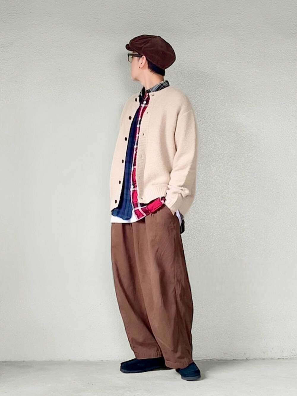 ベージュ系のカーディガン/ボレロ、ブラック系のブーツ、ブラウン系のハンチング/ベレー帽を着用したメンズの秋コーディネートの1枚目の写真