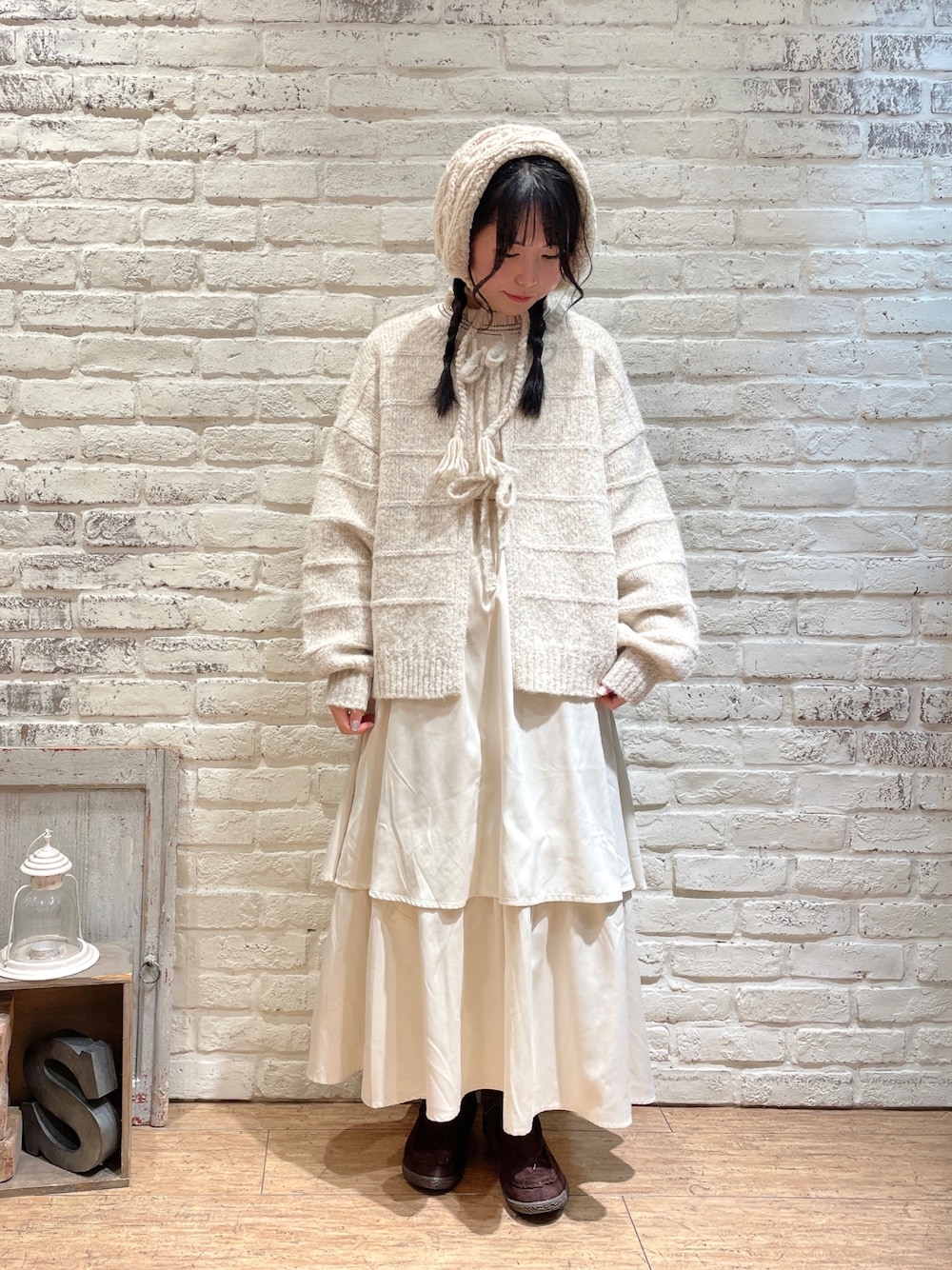 ホワイト系のニット/セーター、ホワイト系のカーディガン/ボレロ、ホワイト系のスカートを着用したレディースの秋コーディネートの1枚目の写真