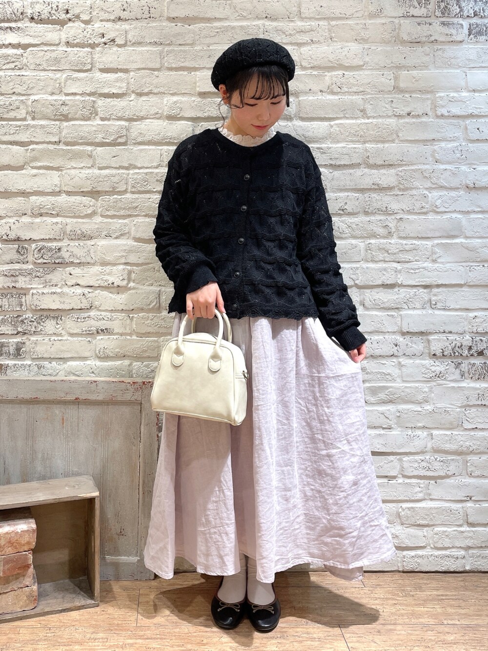 ホワイト系のシャツ/ブラウス、ブラック系のカーディガン/ボレロ、ピンク系のスカートを着用したレディースの春コーディネートの1枚目の写真