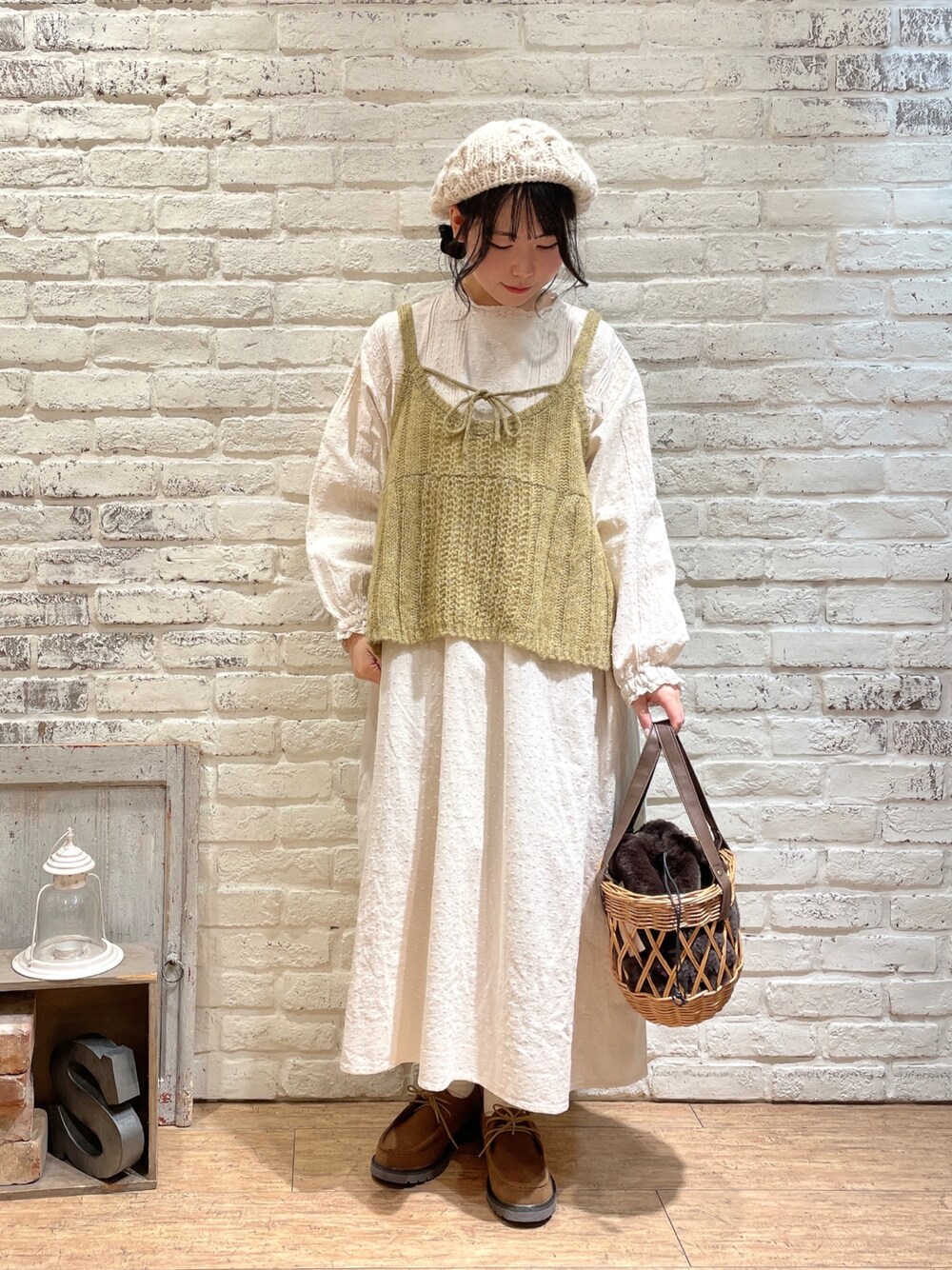 ホワイト系のワンピース、イエロー系のニット/セーター、ブラウン系のハンドバッグを着用したレディースの秋コーディネートの1枚目の写真