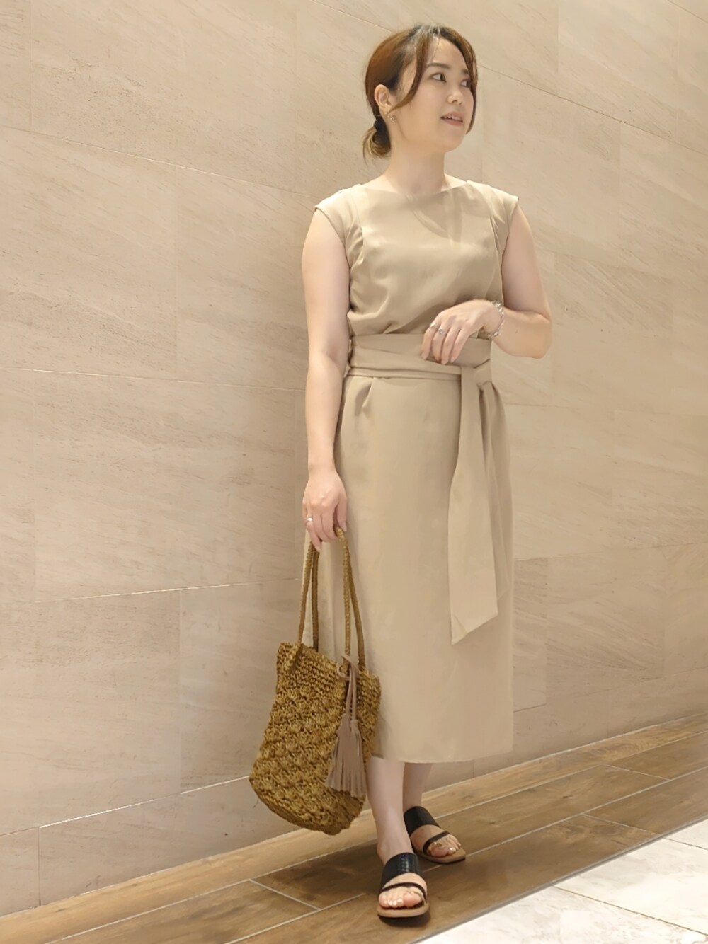 ブラウン系のショルダーバッグ、ブラック系のサンダル、ベージュ系のワンピースを着用したレディースの夏コーディネートの1枚目の写真