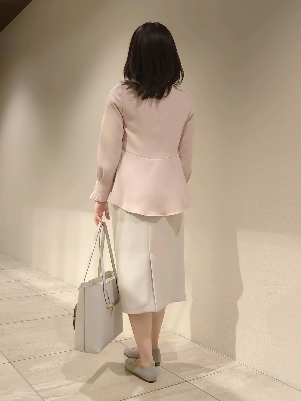 ピンク系のシャツ/ブラウス、ベージュ系のスカート、グレー系のトートバッグを着用したレディースの冬コーディネートの4枚目の写真