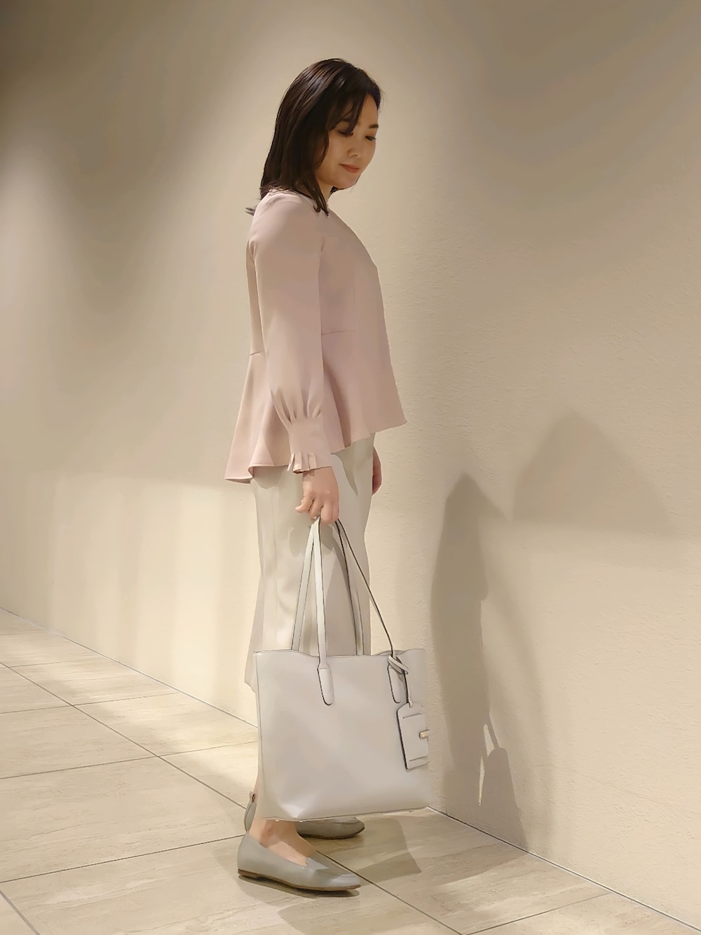 ピンク系のシャツ/ブラウス、ベージュ系のスカート、グレー系のトートバッグを着用したレディースの冬コーディネートの3枚目の写真