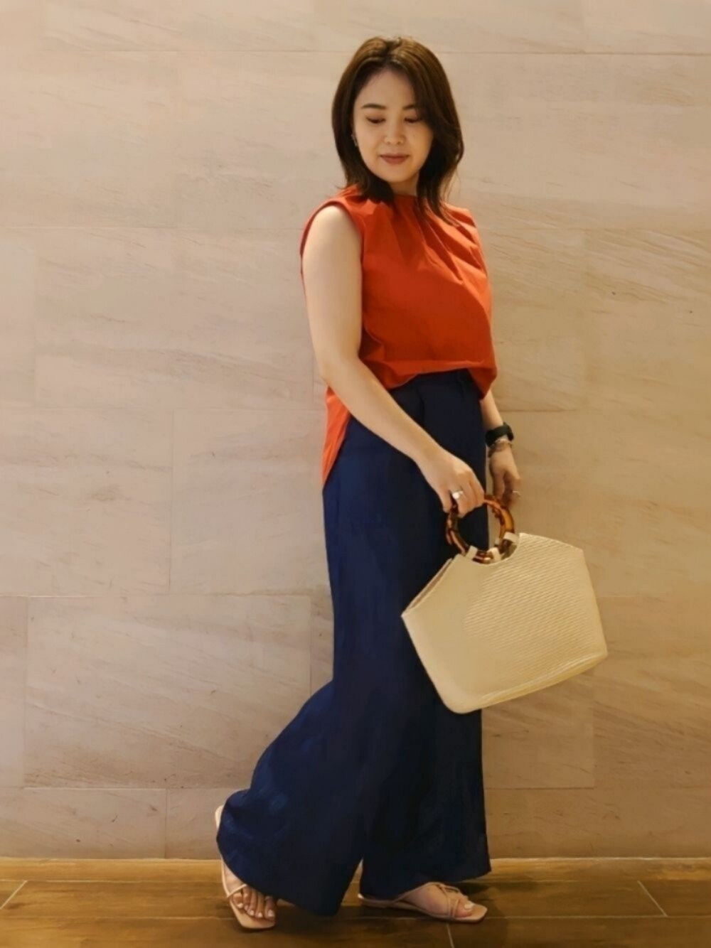 オレンジ系のシャツ/ブラウス、ベージュ系のかごバッグ、ブルー系のその他パンツを着用したレディースの夏コーディネートの1枚目の写真