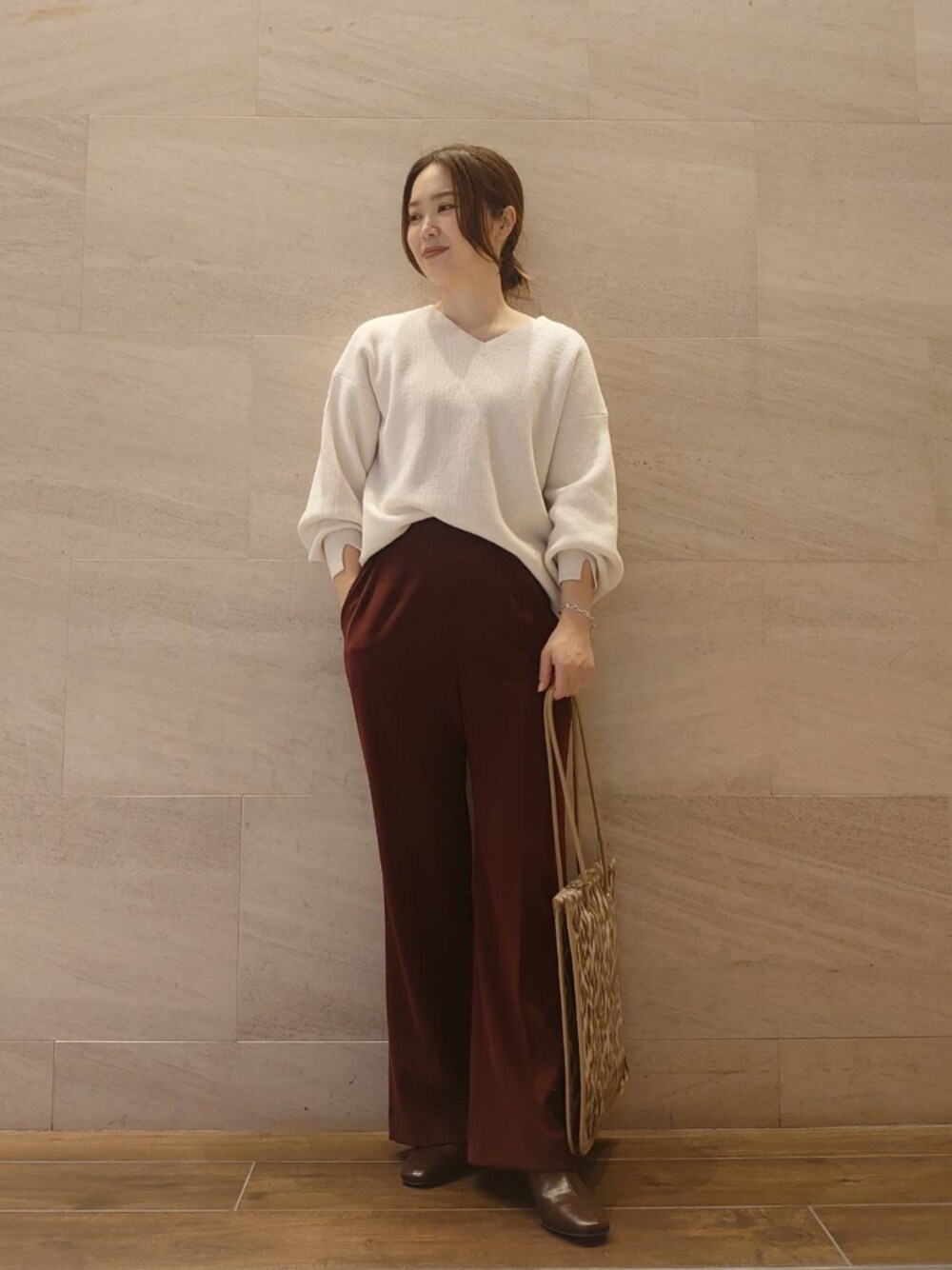 ホワイト系のニット/セーター、レッド系のその他パンツ、その他のトートバッグを着用したレディースの秋コーディネートの1枚目の写真