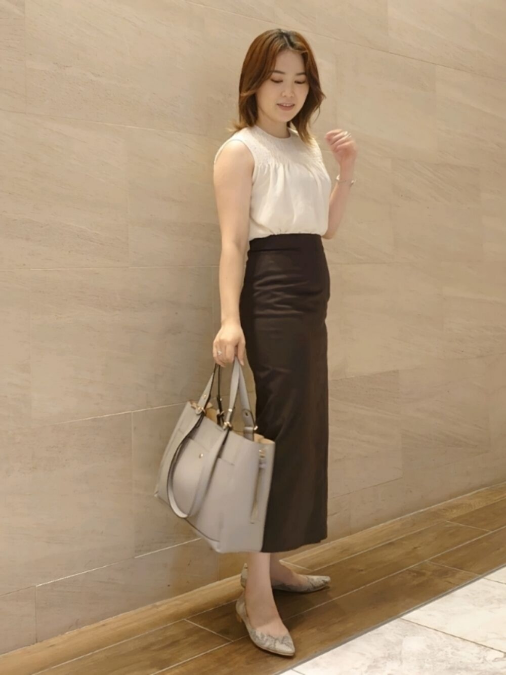 ホワイト系のシャツ/ブラウス、グレー系のスカート、グレー系のトートバッグを着用したレディースの夏コーディネートの1枚目の写真