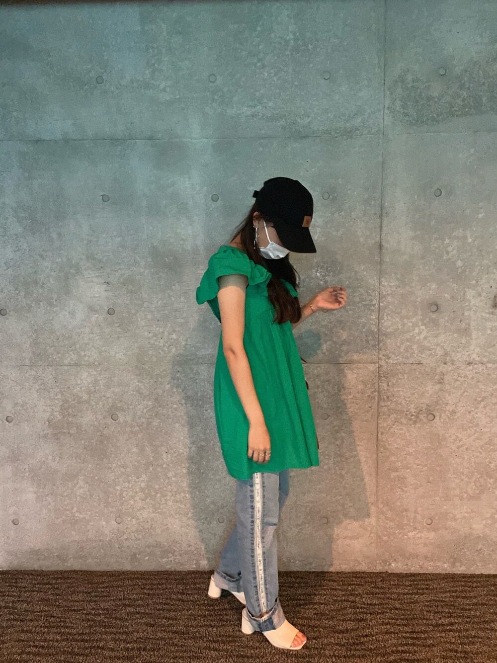 グリーン系のシャツ/ブラウス、ホワイト系のサンダル、ブラック系のキャップを着用したレディースの秋コーディネートの1枚目の写真