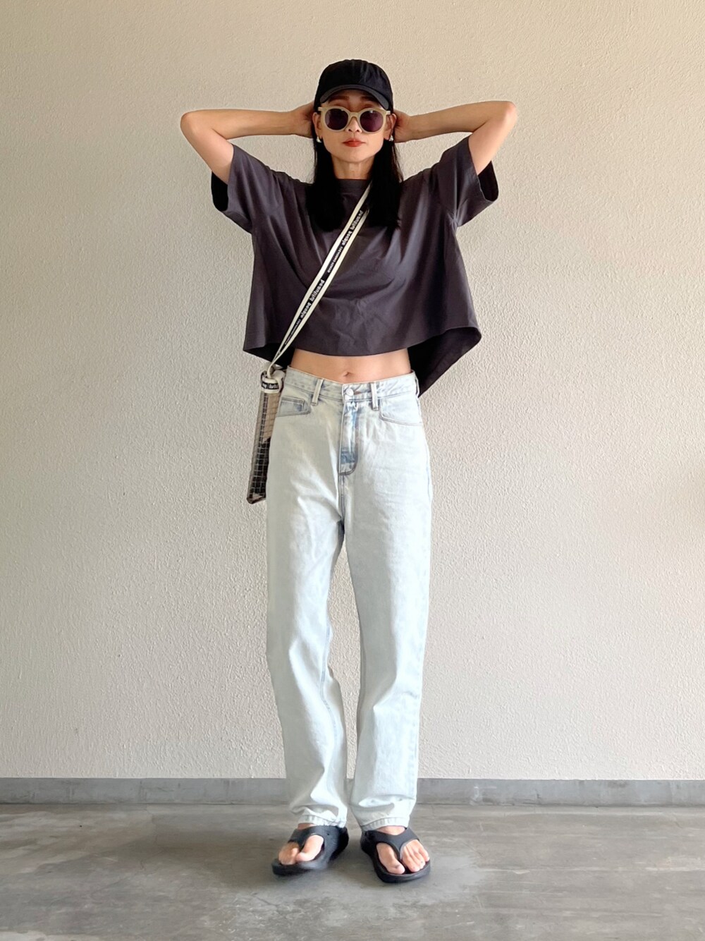 グレー系のTシャツ/カットソー、ブルー系のデニムパンツ、ブラック系のサンダルを着用したレディースの夏コーディネートの1枚目の写真