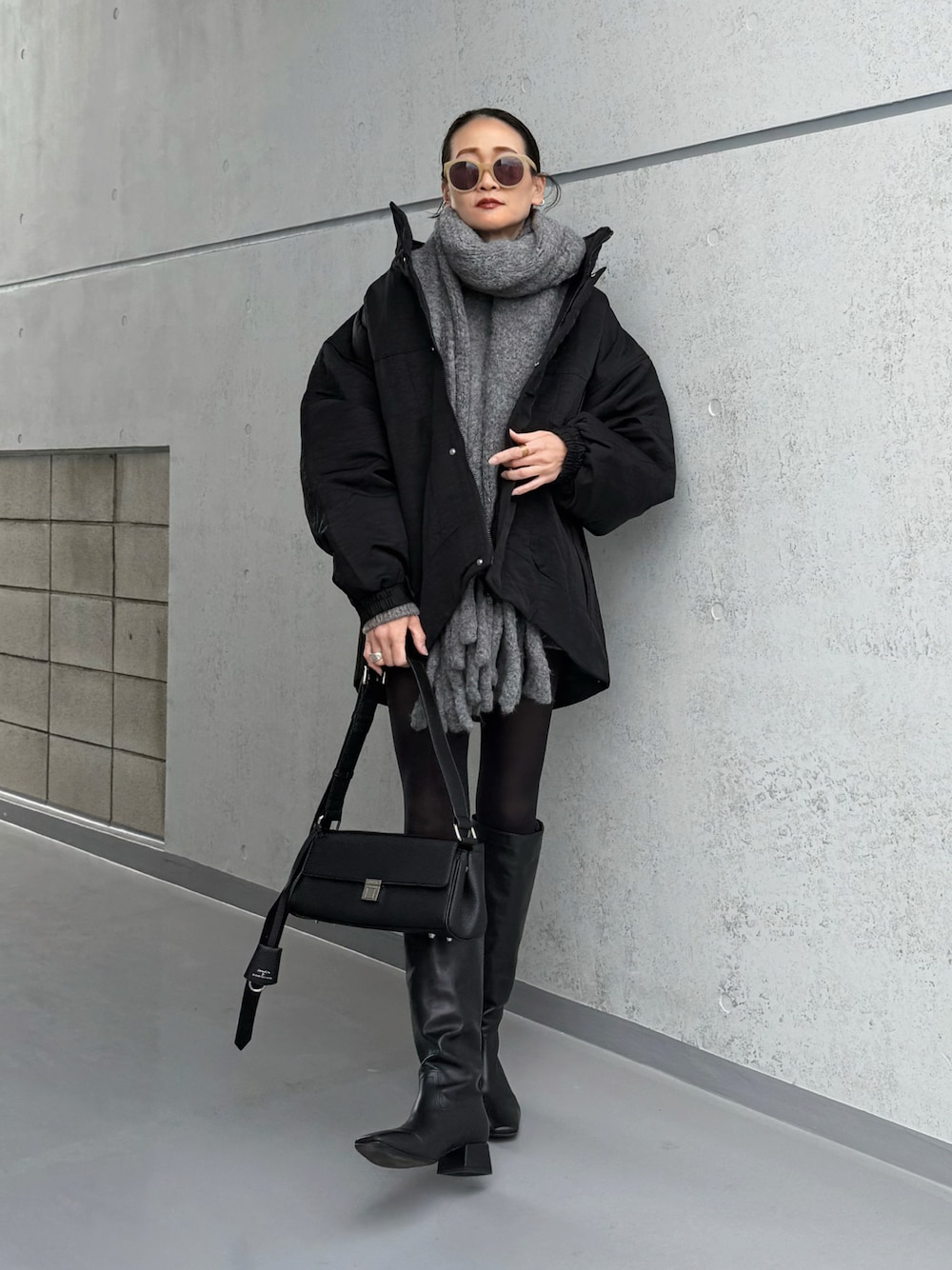 ブラック系のブルゾン、ブラック系のショルダーバッグを着用したレディースの冬コーディネートの1枚目の写真