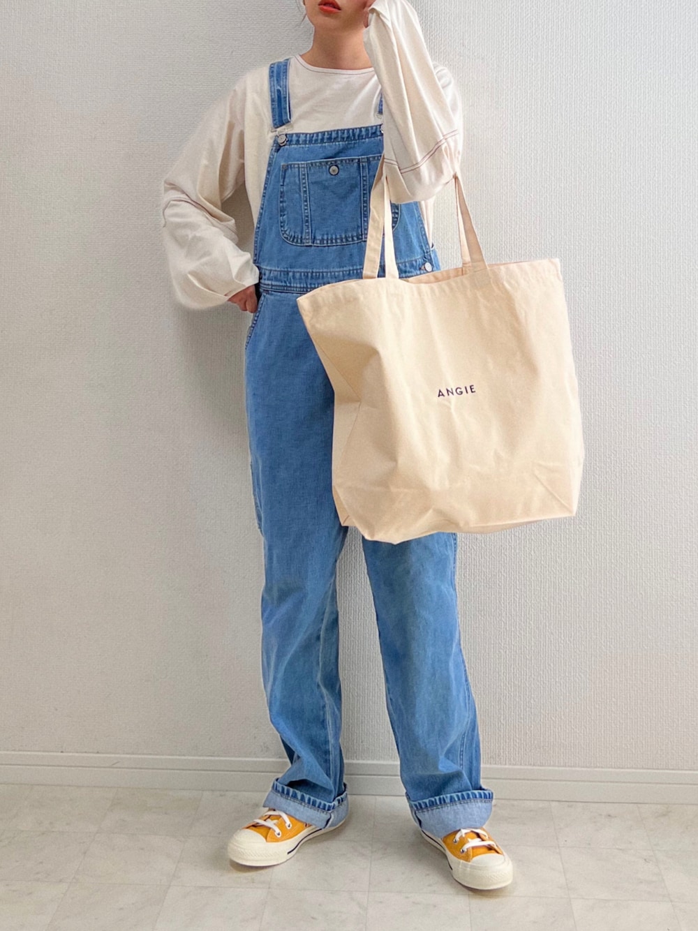ベージュ系のTシャツ/カットソー、ブルー系のサロペット/オーバーオール、ホワイト系のトートバッグを着用したレディースの春コーディネートの1枚目の写真
