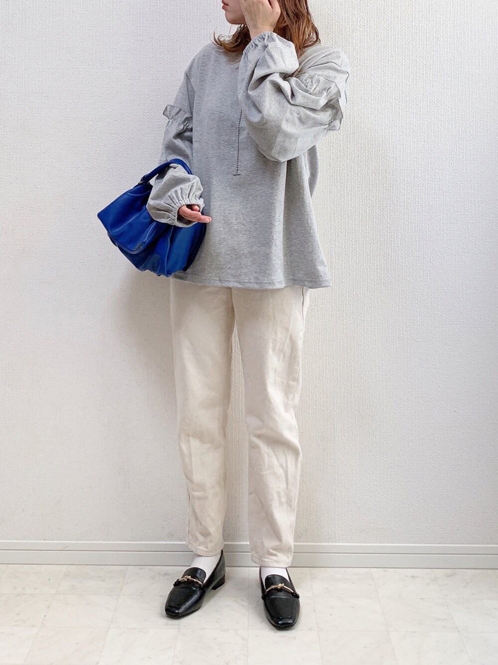 グレー系のTシャツ/カットソー、ブルー系のショルダーバッグ、ベージュ系のその他パンツを着用したレディースの冬コーディネートの1枚目の写真