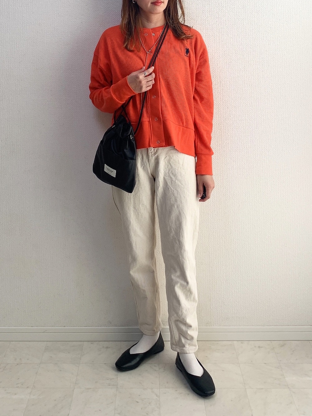 レッド系のカーディガン/ボレロ、ベージュ系のその他パンツ、ブラック系のショルダーバッグを着用したレディースの春コーディネートの1枚目の写真