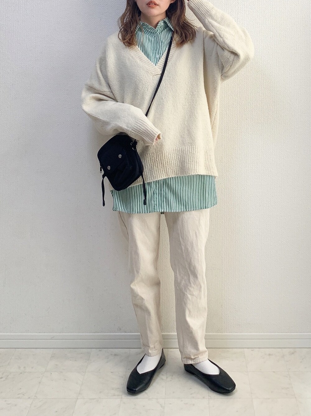 ホワイト系のニット/セーター、ベージュ系のその他パンツ、ブラック系のショルダーバッグを着用したレディースの冬コーディネートの1枚目の写真