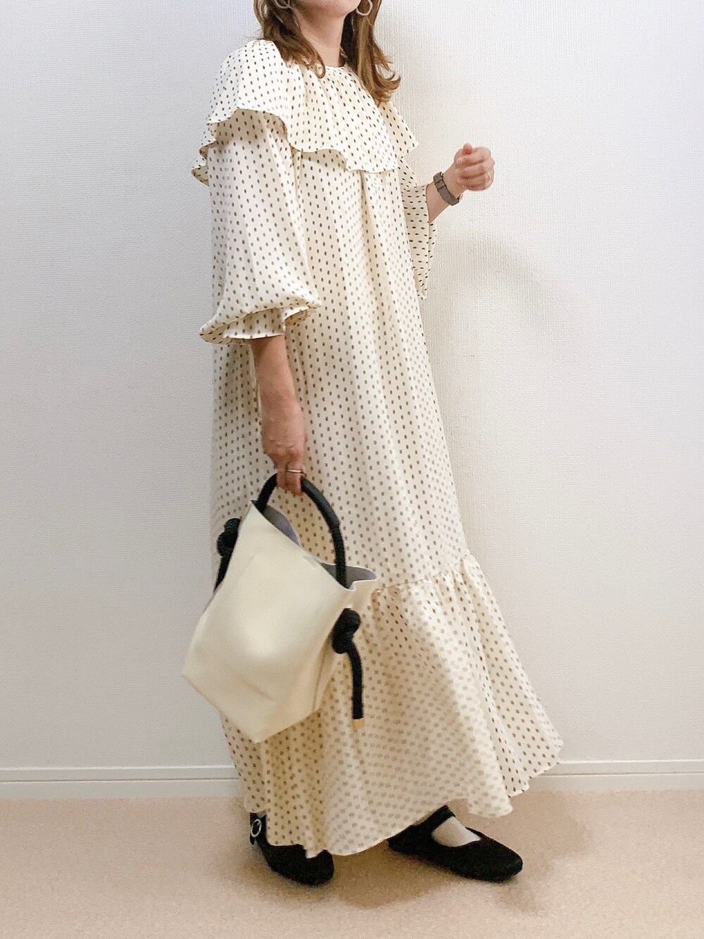 ホワイト系のワンピース、ブラウン系のシューズ、ホワイト系のハンドバッグを着用したレディースの秋コーディネートの1枚目の写真