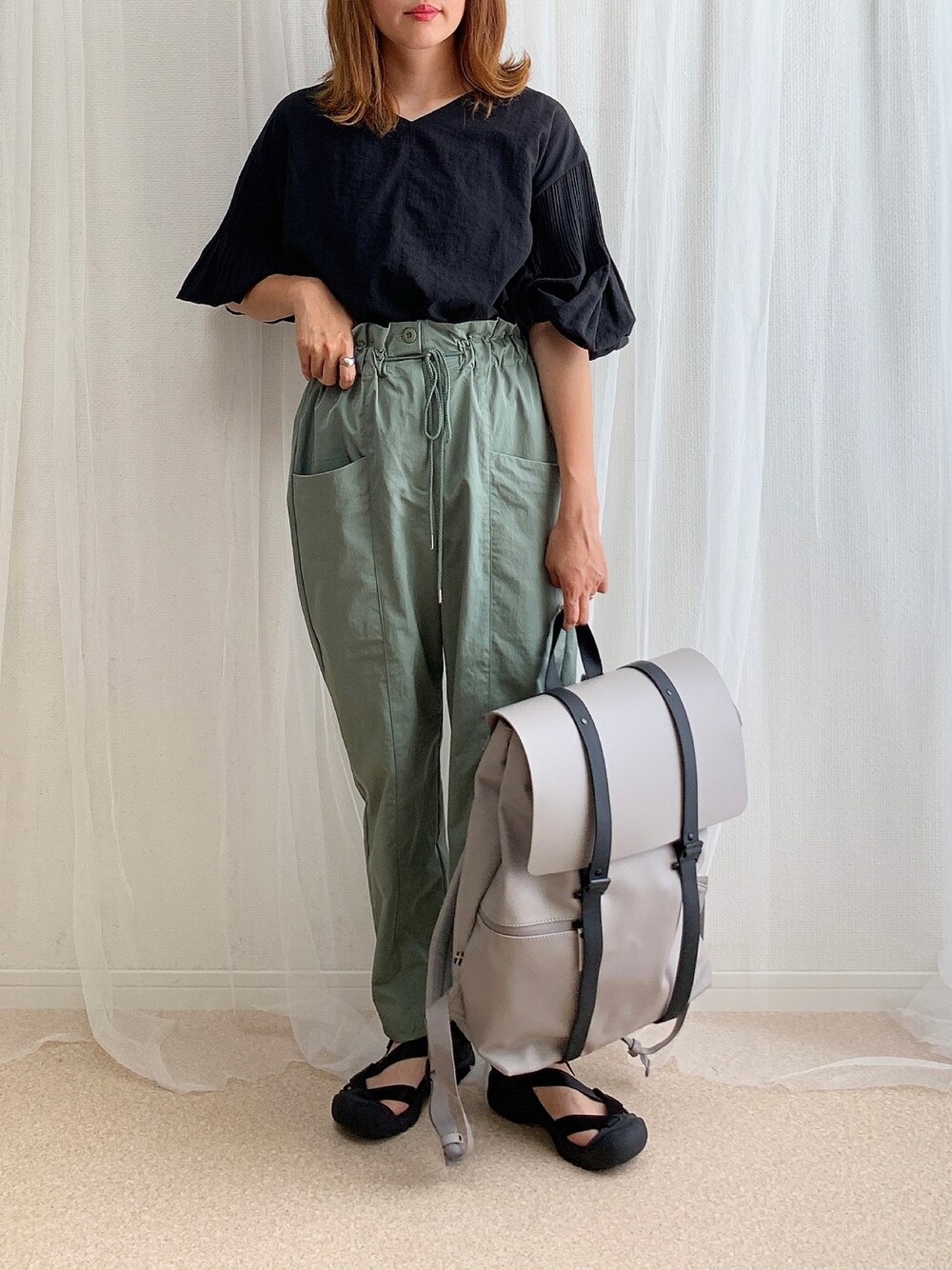 ブラック系のシャツ/ブラウス、グリーン系のその他パンツ、グレー系のバックパック/リュックを着用したレディースの夏コーディネートの1枚目の写真