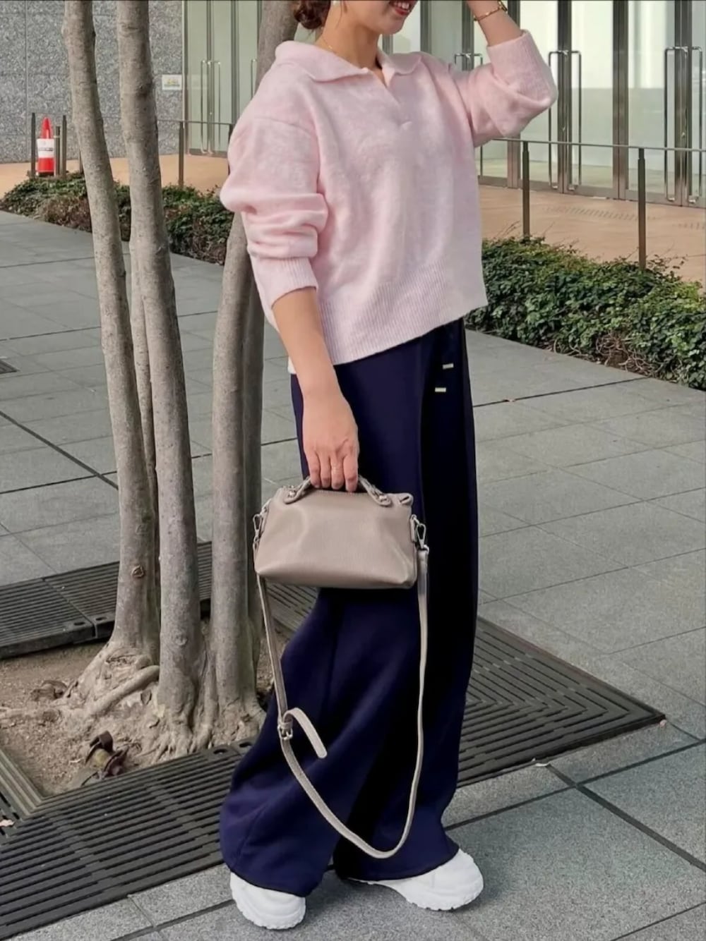 ピンク系のニット/セーター、ブルー系のスウェットパンツ、グレー系のハンドバッグを着用したレディースの冬コーディネートの1枚目の写真