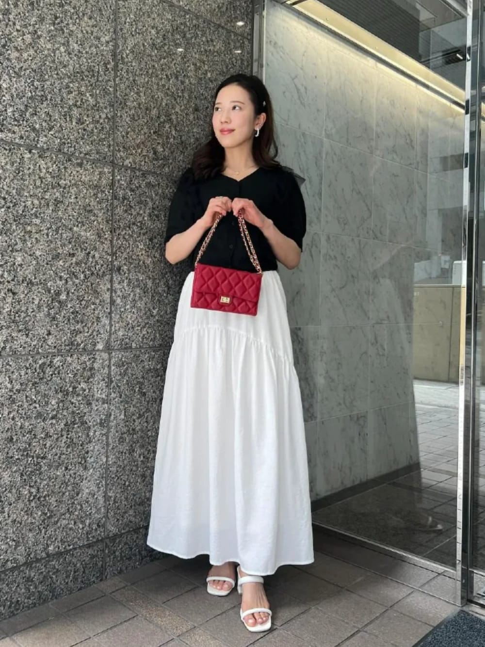 ホワイト系のスカート、ブラック系のカーディガン/ボレロを着用したレディースの夏コーディネートの1枚目の写真