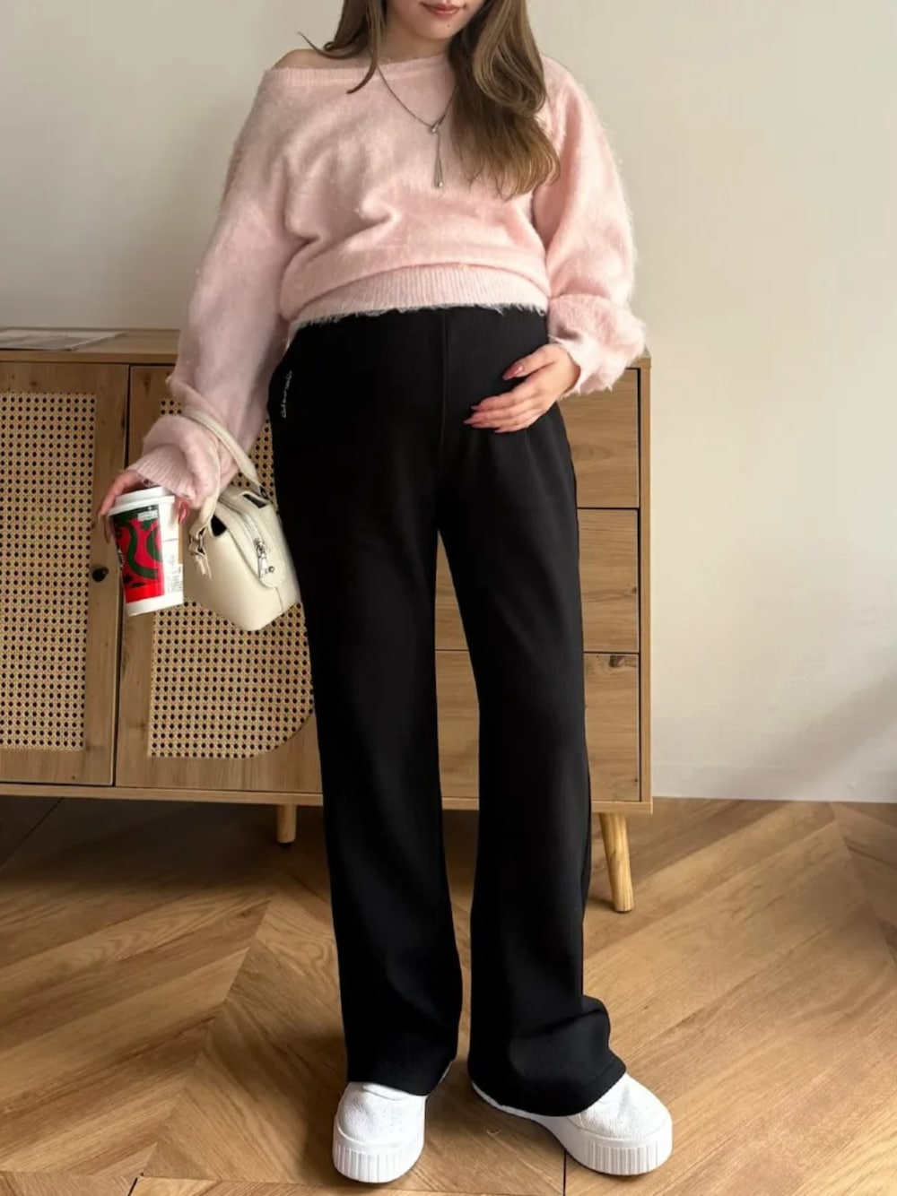 ブラック系のスウェットパンツ、ピンク系のニット/セーターを着用したレディースの冬コーディネートの1枚目の写真