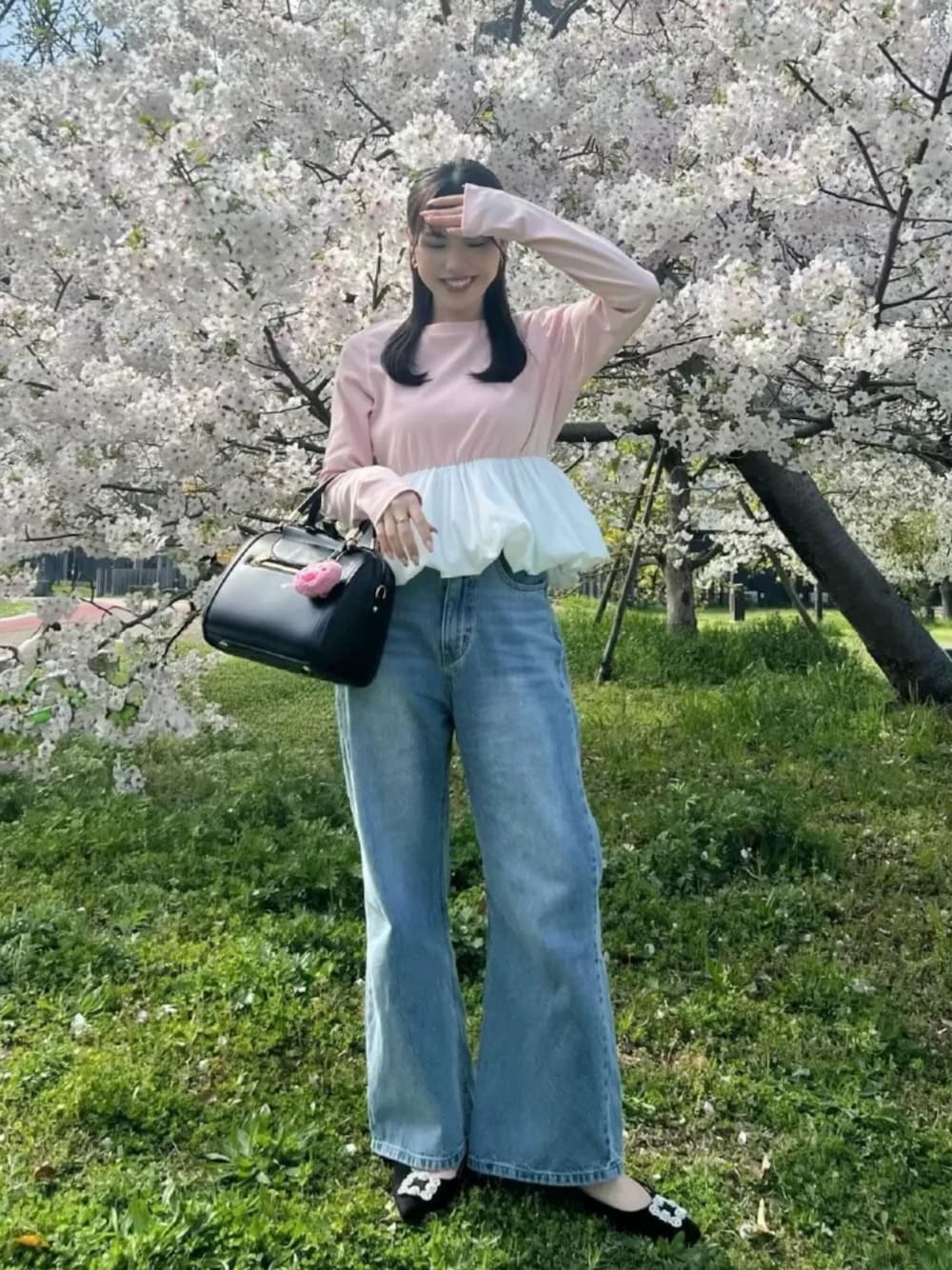 ブラック系のパンプス、ブラック系のボストンバッグ、ピンク系のTシャツ/カットソーを着用したレディースの夏コーディネートの1枚目の写真