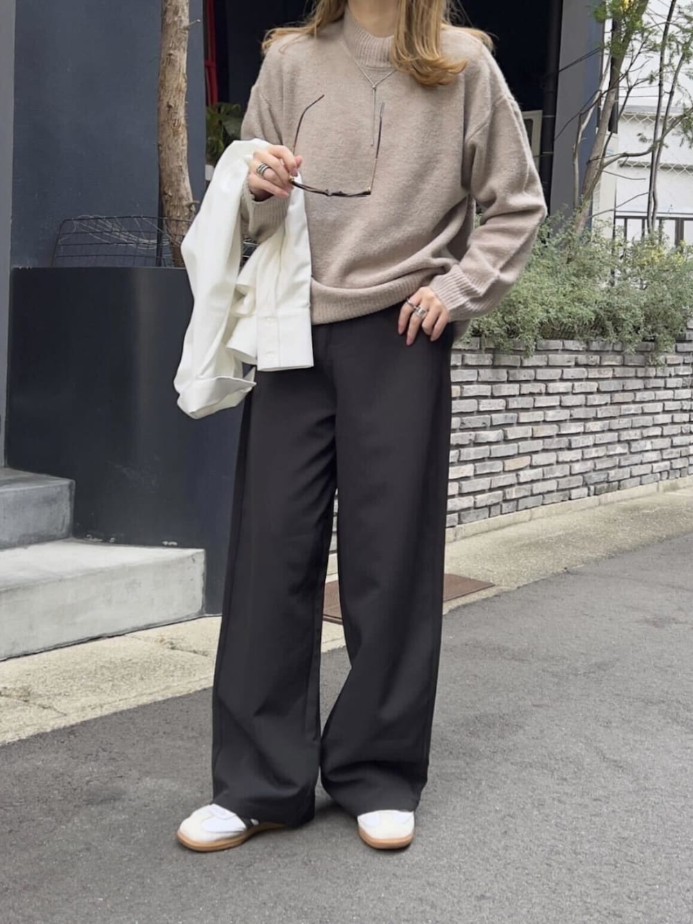 ブラック系のその他パンツ、ベージュ系のニット/セーターを着用したレディースの冬コーディネートの1枚目の写真
