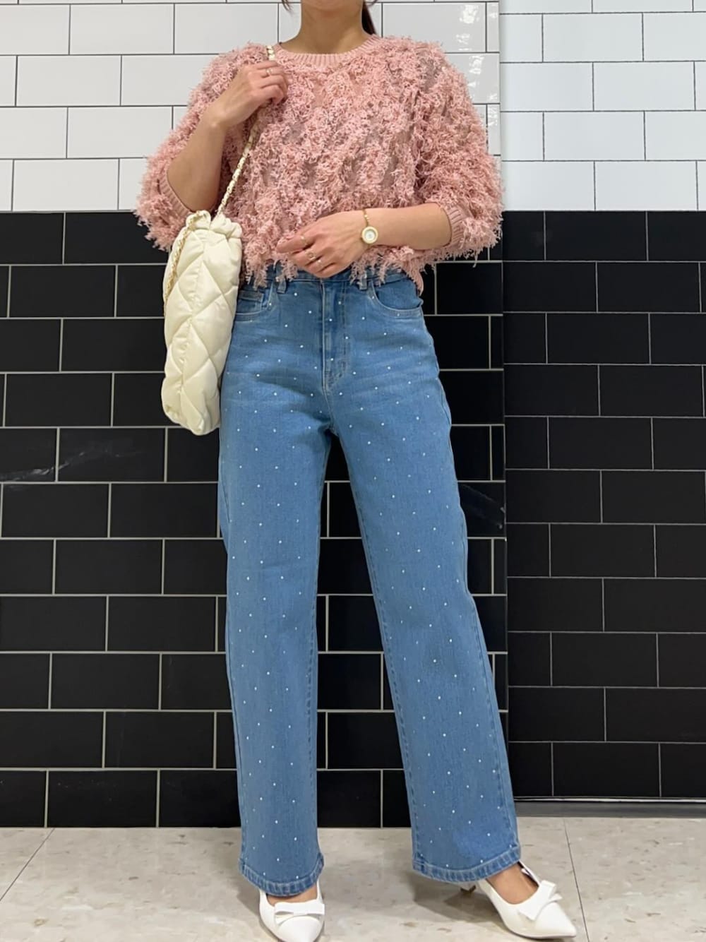 ピンク系のTシャツ/カットソー、ブルー系のデニムパンツ、ホワイト系のパンプスを着用したレディースの秋コーディネートの1枚目の写真