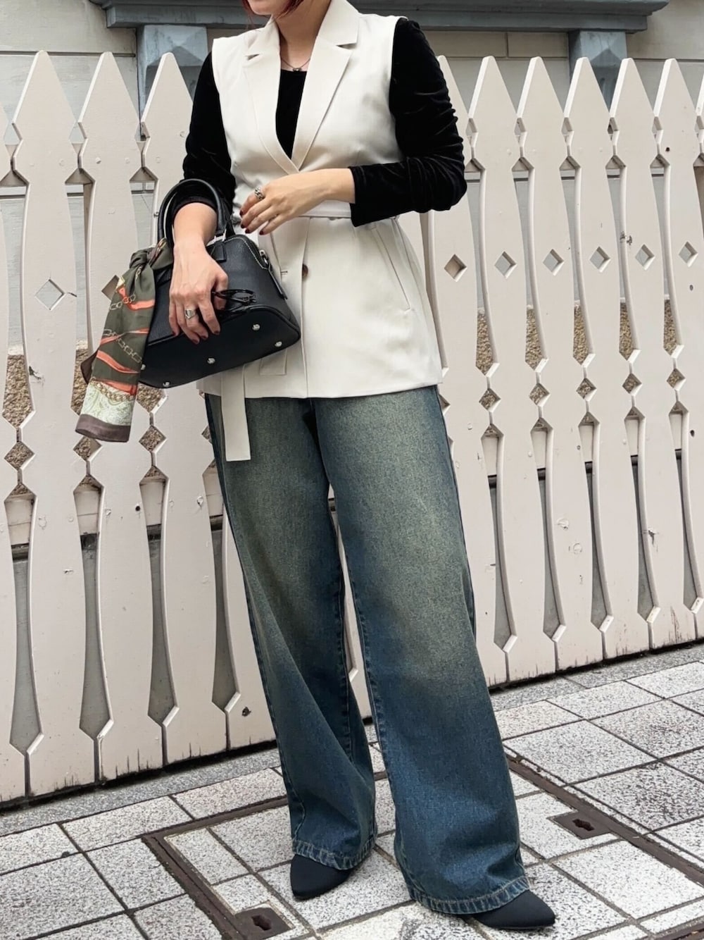 ブラック系のTシャツ/カットソー、ベージュ系のベスト、その他のデニムパンツを着用したレディースの秋コーディネートの1枚目の写真