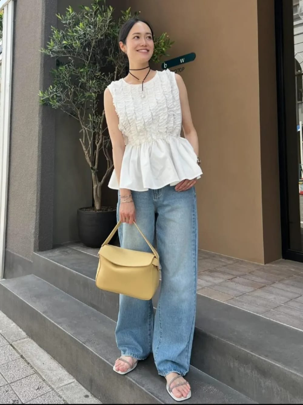 ブルー系のデニムパンツ、イエロー系のショルダーバッグ、ホワイト系のシャツ/ブラウスを着用したレディースの夏コーディネートの1枚目の写真