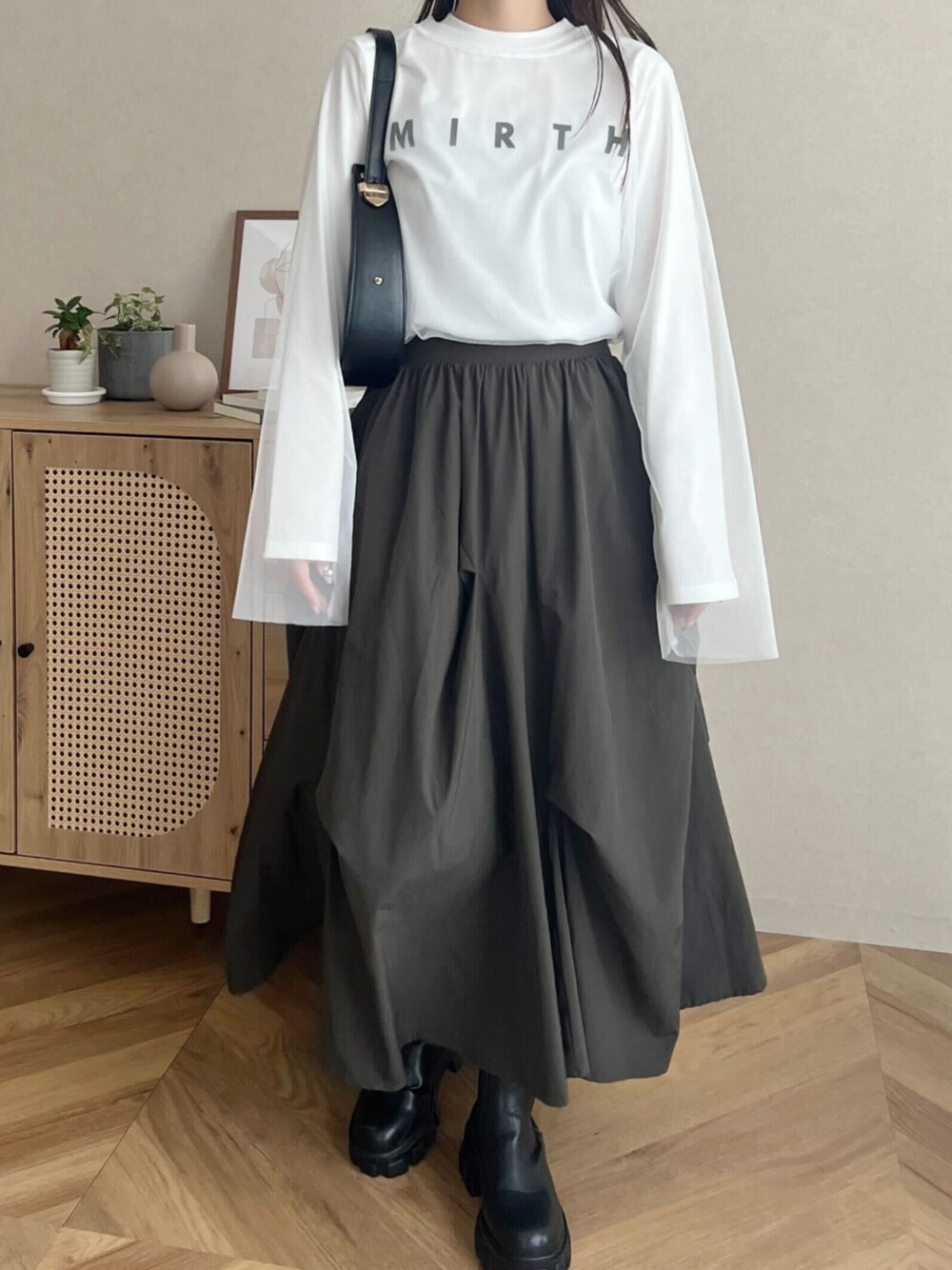 ホワイト系のTシャツ/カットソー、グリーン系のスカートを着用したレディースの秋コーディネートの1枚目の写真