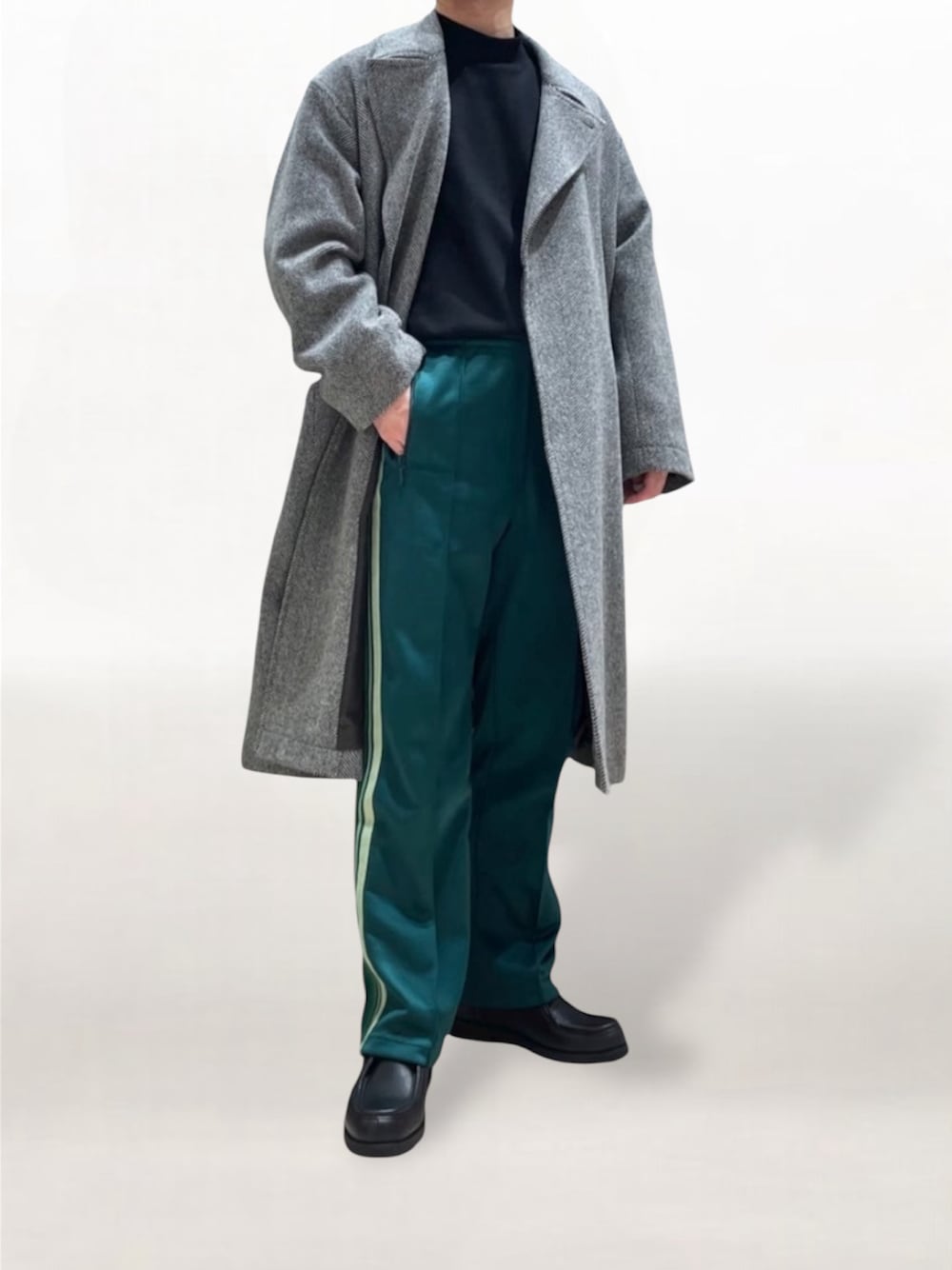 グレー系のチェスターコート、グリーン系のその他パンツ、ブラック系のモカシン/デッキシューズを着用したメンズの秋コーディネートの1枚目の写真