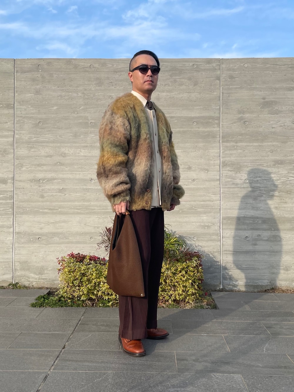 イエロー系のカーディガン/ボレロ、ブラウン系のその他パンツ、ブラウン系のバッグを着用したメンズの冬コーディネートの1枚目の写真