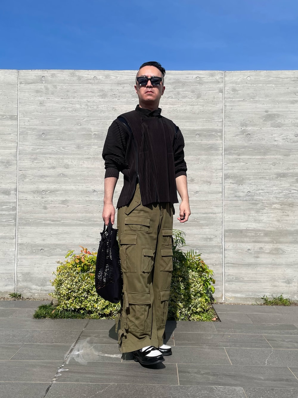 ブラック系のローファー、グリーン系のカーゴパンツ、ブラウン系のブルゾンを着用したメンズの夏コーディネートの1枚目の写真