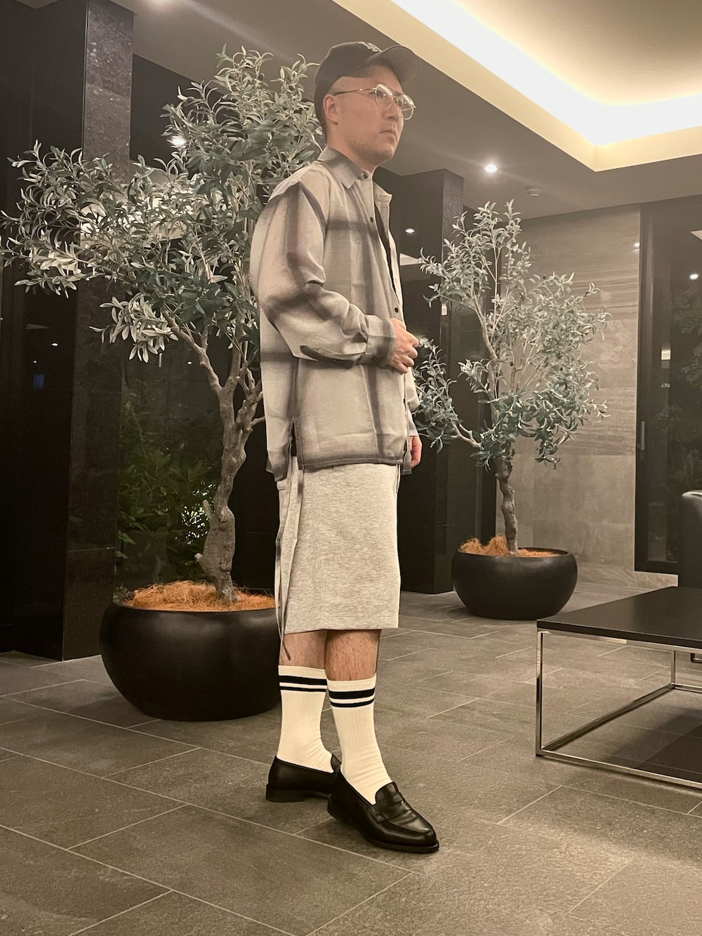 ホワイト系のシャツ/ブラウス、グレー系のスウェットパンツ、ブラック系のローファーを着用したメンズの夏コーディネートの1枚目の写真