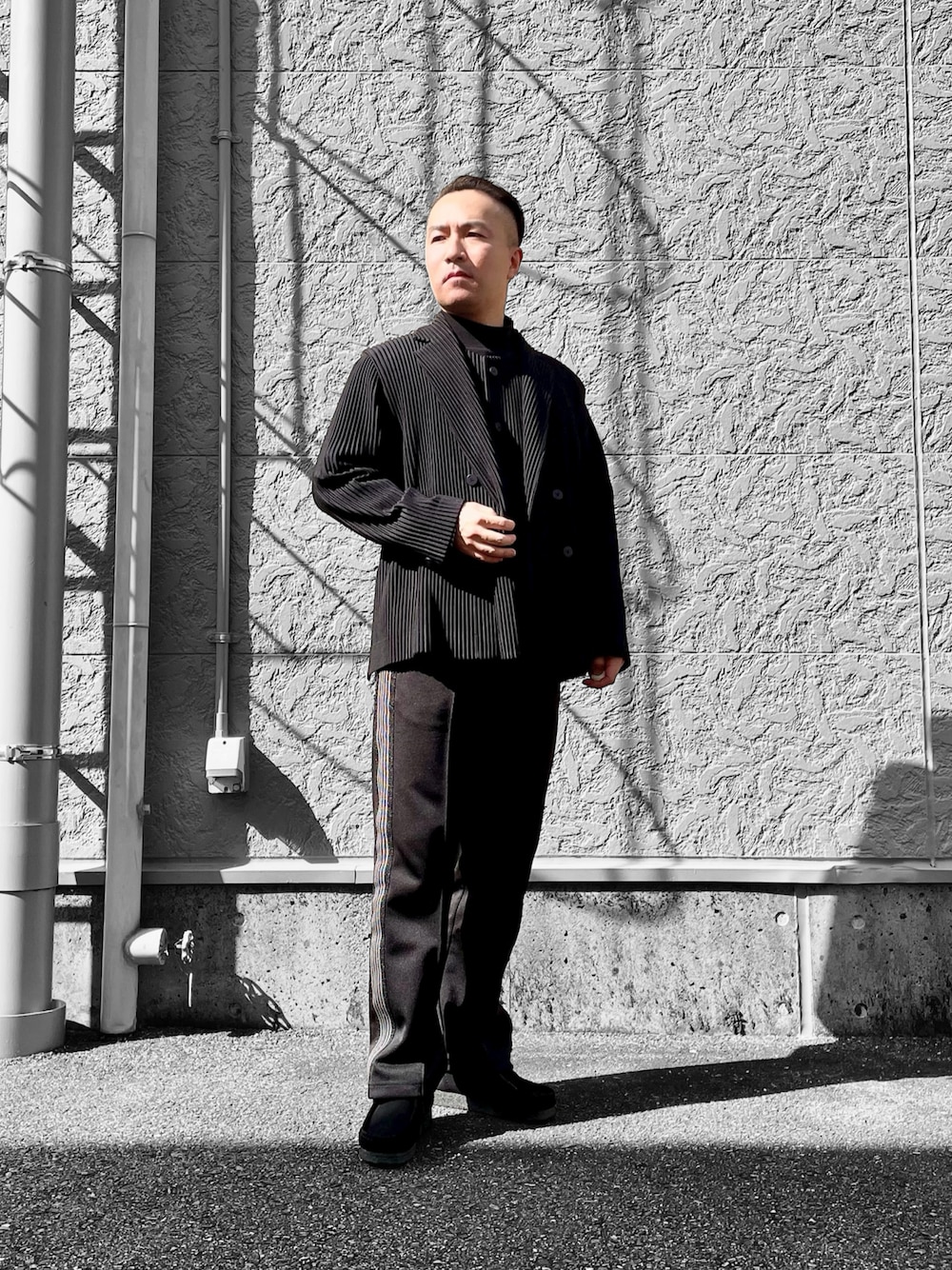 ブラック系のブーツ、ブラック系のベスト、ブラック系のテーラードジャケットを着用したメンズの春コーディネートの1枚目の写真