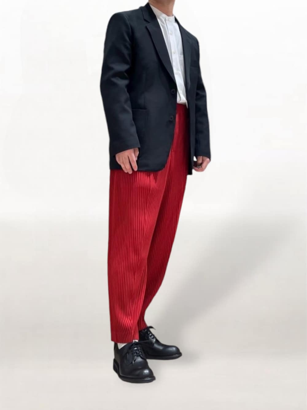 ブラック系のテーラードジャケット、レッド系のスラックス、ブラック系のドレスシューズを着用したメンズの秋コーディネートの1枚目の写真