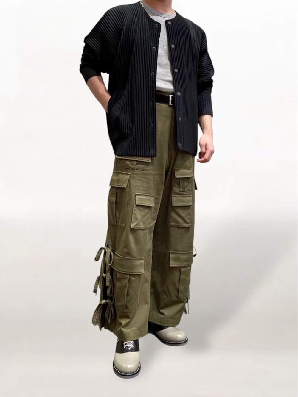 ブラック系のカーディガン/ボレロ、グリーン系のカーゴパンツ、ブラック系のドレスシューズを着用したメンズの秋コーディネートの1枚目の写真