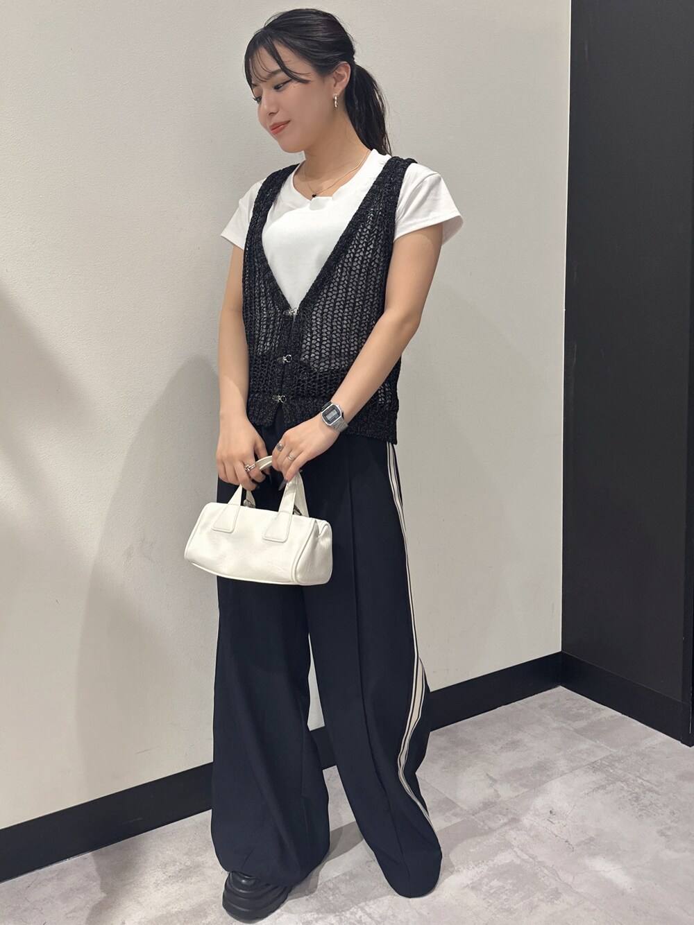 ブラック系のベスト、ホワイト系のTシャツ/カットソー、ブルー系のスラックスを着用したレディースの夏コーディネートの1枚目の写真
