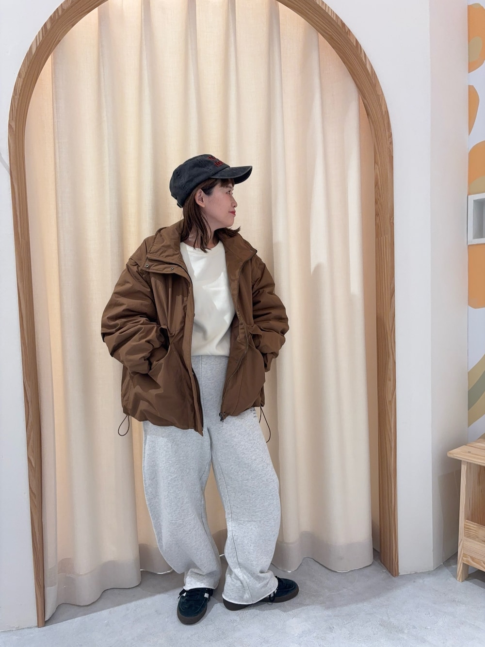 ホワイト系のニット/セーター、ブラウン系のブルゾン、ホワイト系のスウェットパンツを着用したレディースの秋コーディネートの1枚目の写真