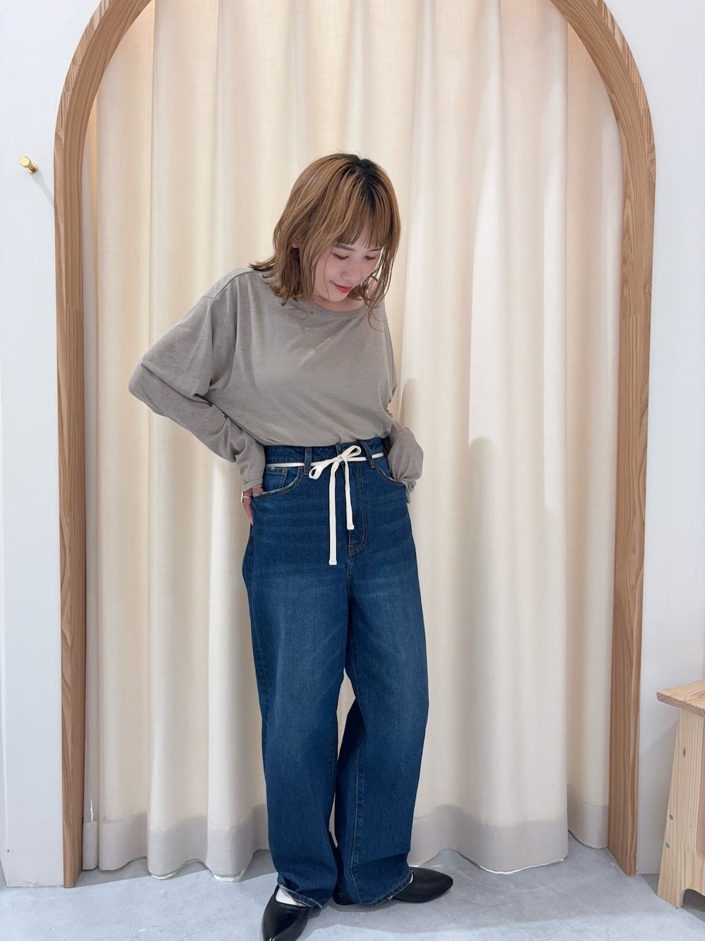 ブルー系のデニムパンツ、ベージュ系のTシャツ/カットソー、ブラック系のパンプスを着用したレディースの秋コーディネートの1枚目の写真