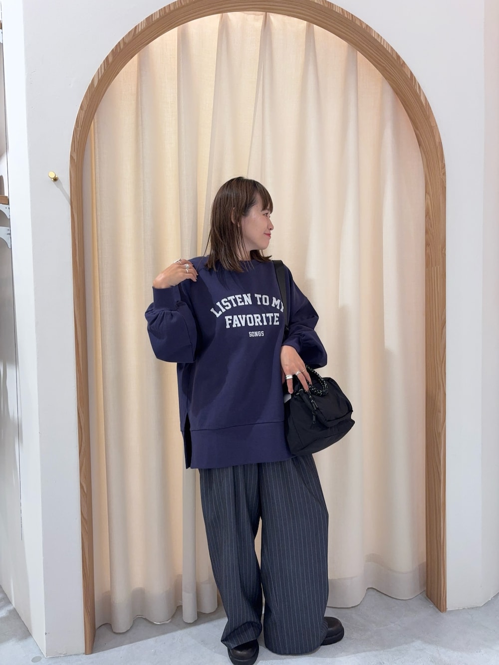 ブルー系のスウェット、グレー系のスラックス、ブラック系のトートバッグを着用したレディースの秋コーディネートの1枚目の写真