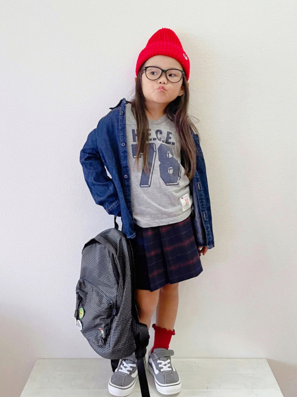 「チェック、スニーカー、スカート、ニット帽、めがね、UNIQLO、ミニスカート、デニムシャツ、プチプラ、黒リュック、シャツスタイル、カジュアルコーデ、フットボールTシャツ、秋コーデ、チェック柄に恋してる」｜「Championの【Champion】ブランド マーク ワッペン付き ニット 帽子(590-002A)(EL)（ニットキャップ/ビーニー、レッド系）」を使った、sui_mmyさん（キッズ・100cm）の秋コーディネートの1枚目の写真