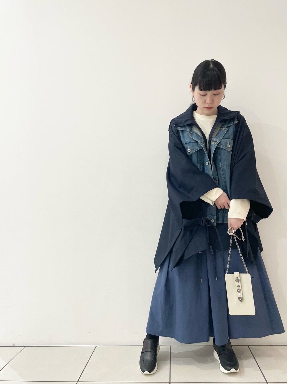 「お出かけコーデ、きれいめカジュアル、大人コーデ、レイヤードスタイル、ビッグシルエット、ボリューム袖、厚底シューズ、ブルー、ポンチョ、ミニバッグ、ショルダーバッグ、チェーンバッグ、ローファー、ロングスカート、B2nd」｜「DROIT BELLOのDROIT BELLO(ドロイトベロ)別注メタルスタッズ付きバック（ショルダーバッグ、ホワイト系）」を使った、ISAさん（レディース・160cm）の春コーディネートの1枚目の写真
