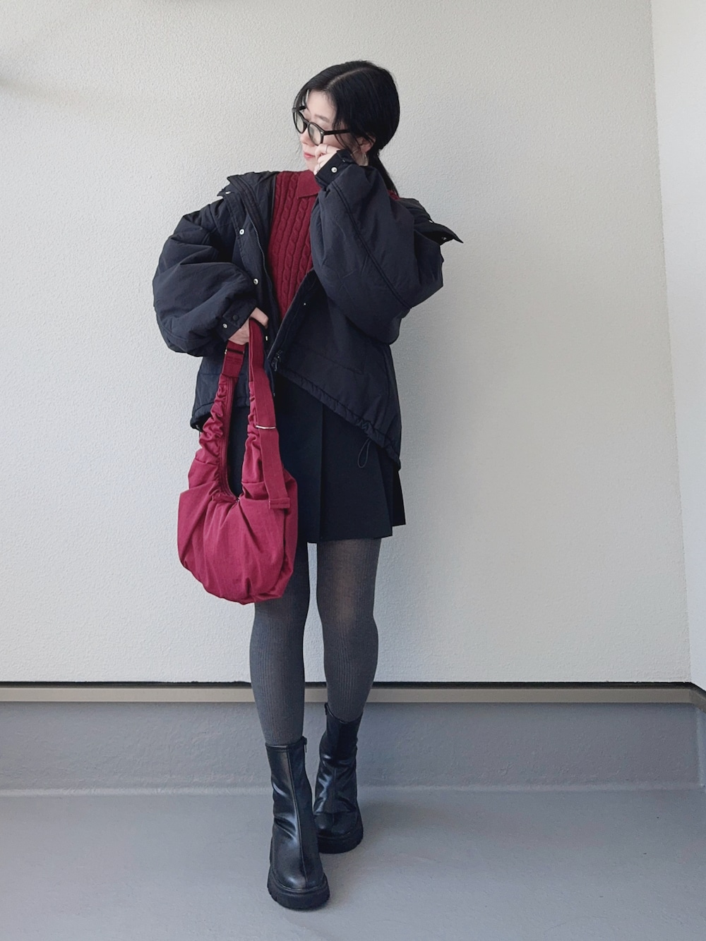 レッド系のニット/セーター、ブラック系のブルゾン、ブラック系のブーツを着用したレディースの秋コーディネートの1枚目の写真