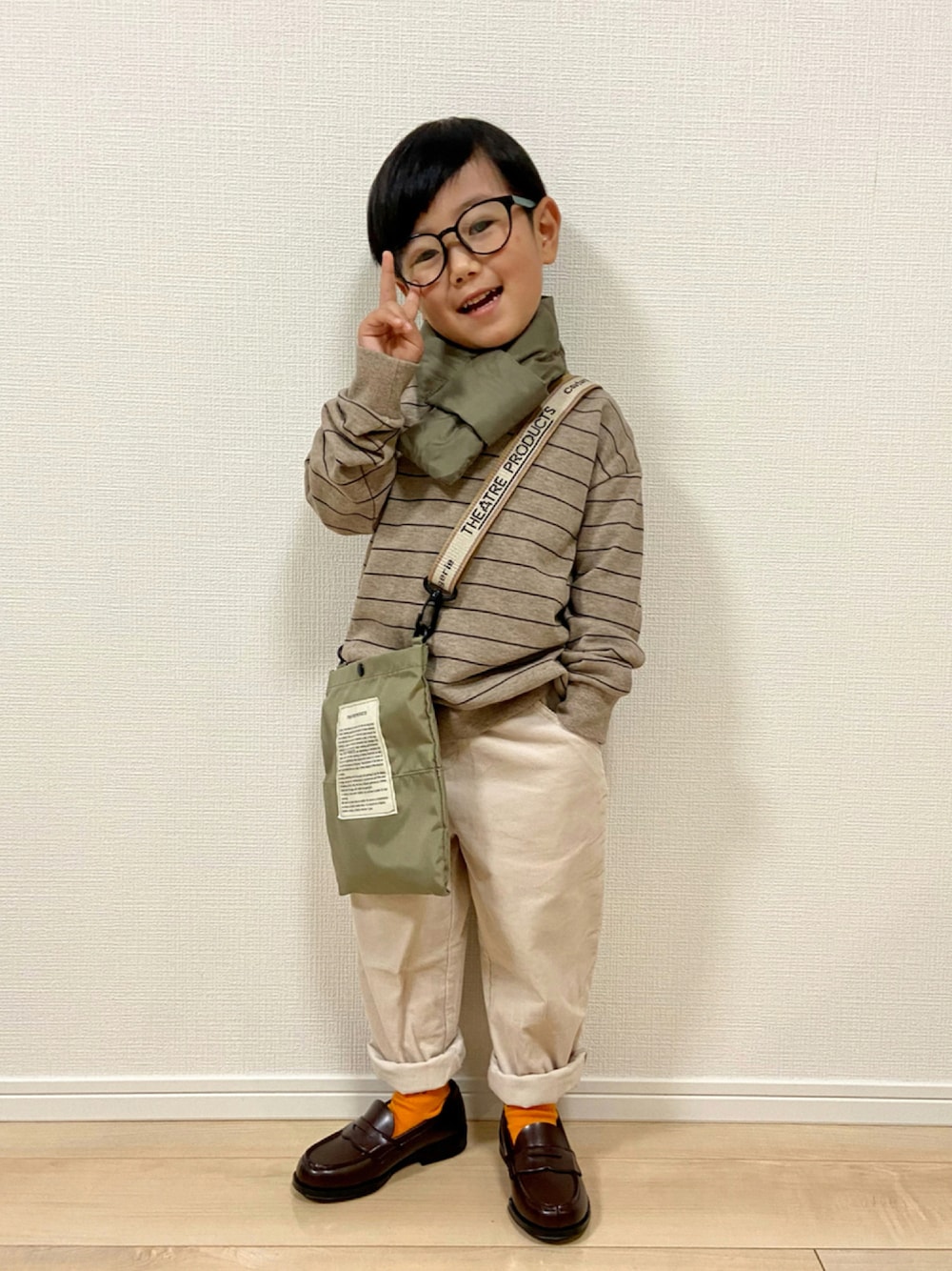 ブラウン系のTシャツ/カットソー、ホワイト系のパンツ、ブラウン系のローファーを着用したキッズの秋コーディネートの1枚目の写真