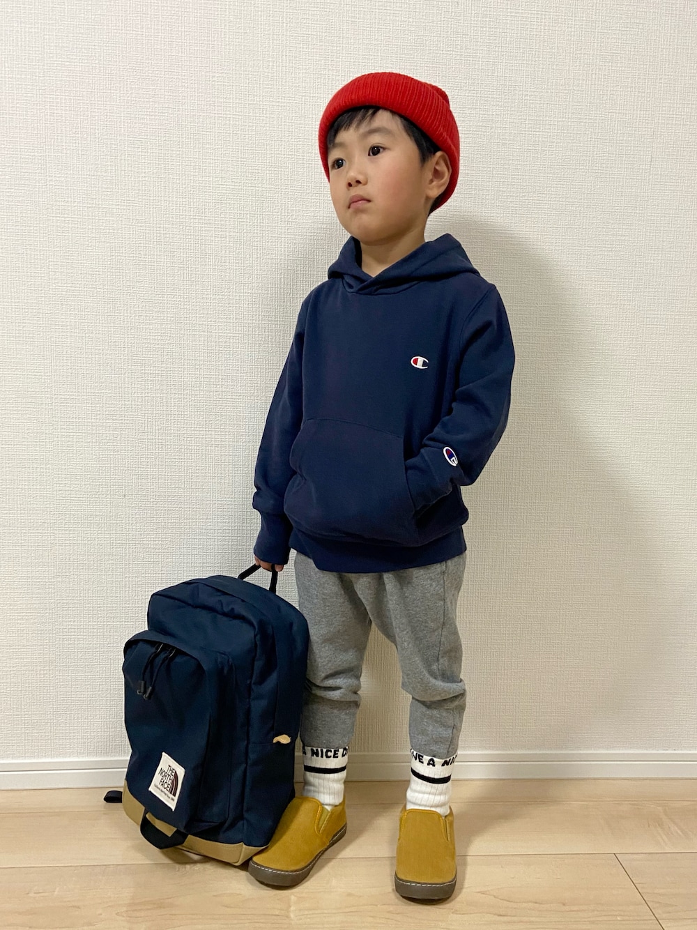 ブルー系のパーカー、グレー系のスウェットパンツ、イエロー系のスリッポンを着用したキッズの冬コーディネートの1枚目の写真