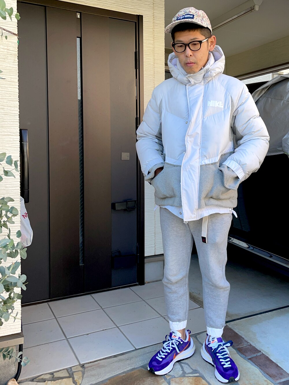 「supreme、キャップ、ダウンジャケット、sacai、NIKE、スニーカー、sacai×nike、GRAMICCI、グラミチ、スウエットパンツ」｜「Sacaiのアイテム（スウェットパンツ、グレー系）」を使った、KHさん（メンズ・170cm）の冬コーディネートの1枚目の写真